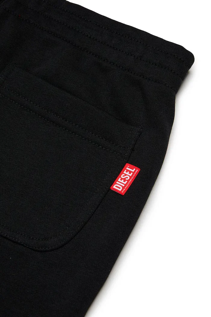 Diesel панталон джогър за деца с памук PRES TROUSERS черен със стандартна талия J03031